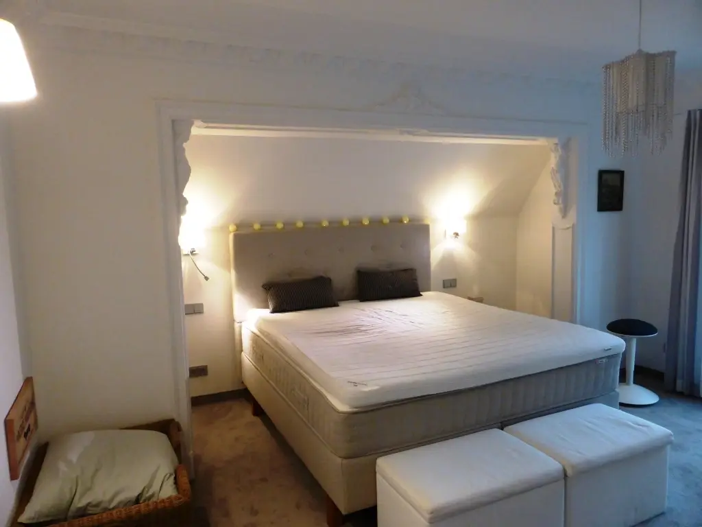 Schlafzimmer mit dekorativer Stuckdecke und Doppelbett