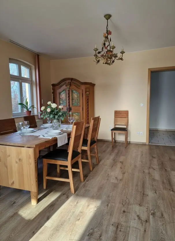 Großzügiges Esszimmer mit gedecktem Holztisch und Bogenfenster