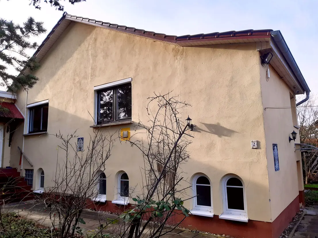 Vorderansicht des Einfamilienhauses mit mediterranen Bogenfenstern im Untergeschoss