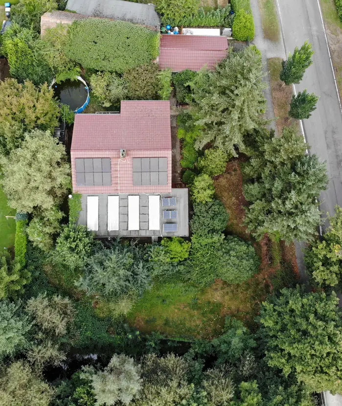 Senkrechte Luftaufnahme des Grundstücks mit Wohnhaus, Photovoltaikanlage und Nebengebäude