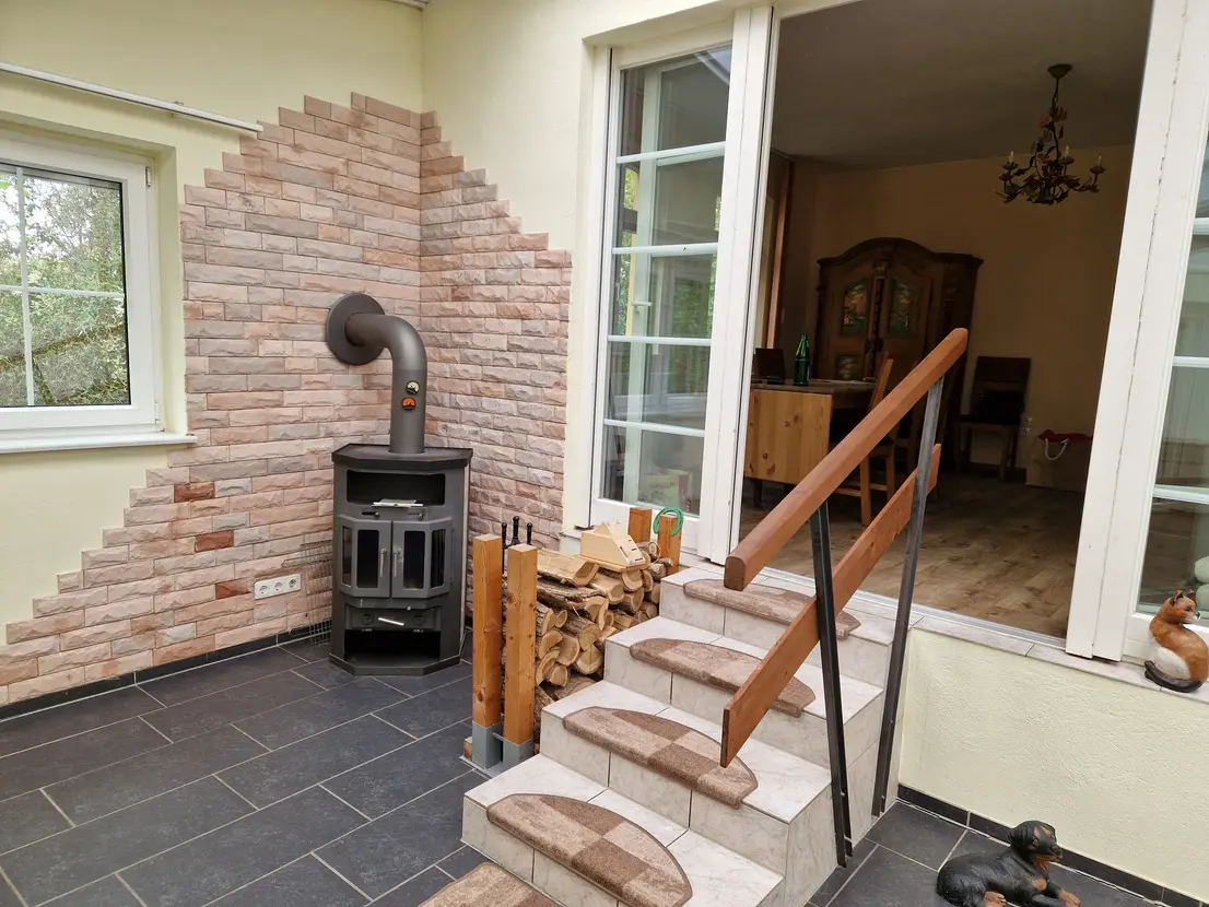 Kamin und geflieste Treppe zwischen Wintergarten und Esszimmer