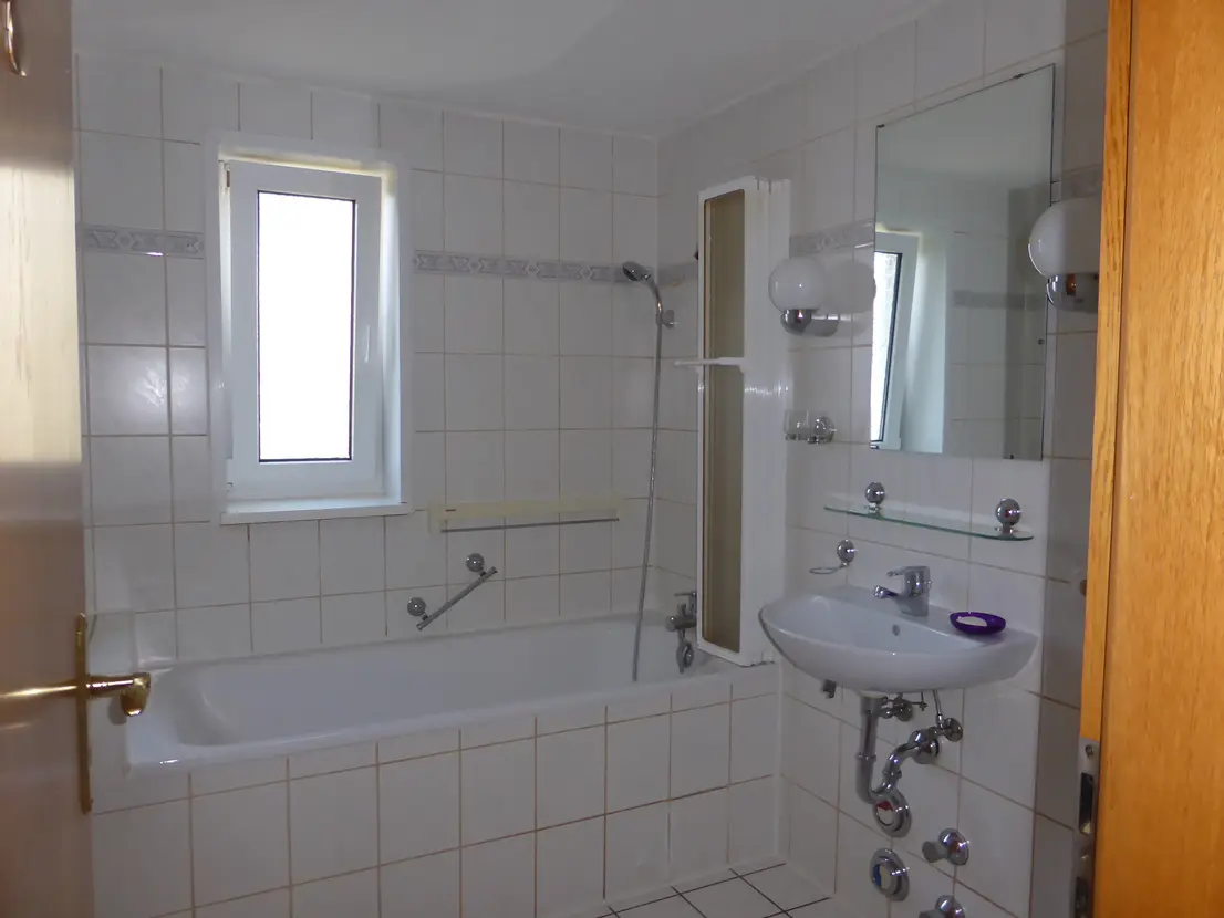Badezimmer mit Badewanne und Duschabtrennung