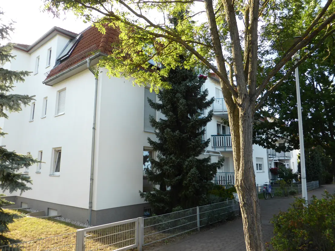 Wohnhaus hinter einer gewachsenen Baumreihe