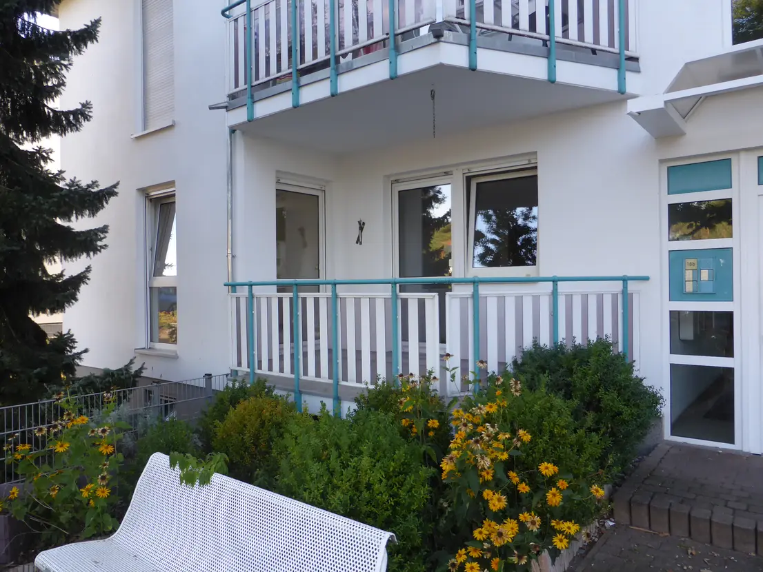 Wohngebäude mit Balkonen und begrüntem Vorgarten
