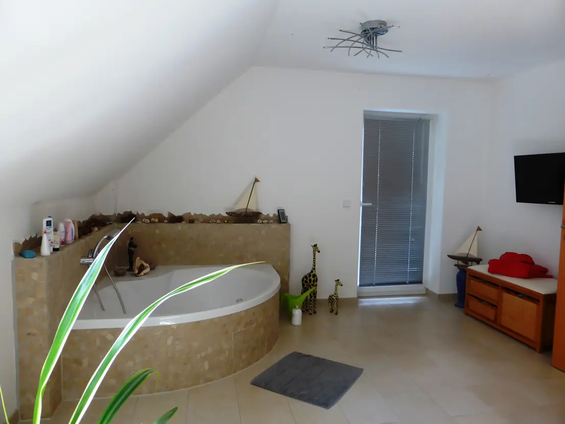 Badezimmer mit Eckbadewanne und hochwertiger Verfliesung