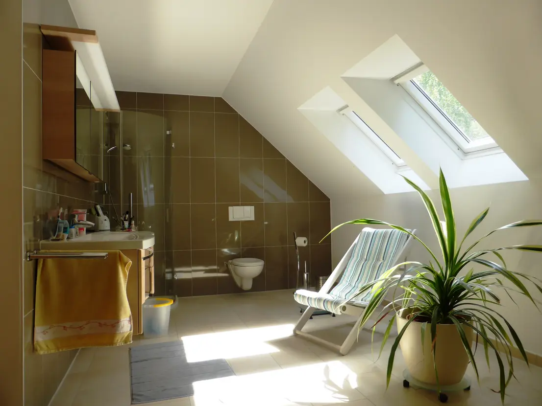 Großes Badezimmer mit Runddusche und Dachflächenfenstern