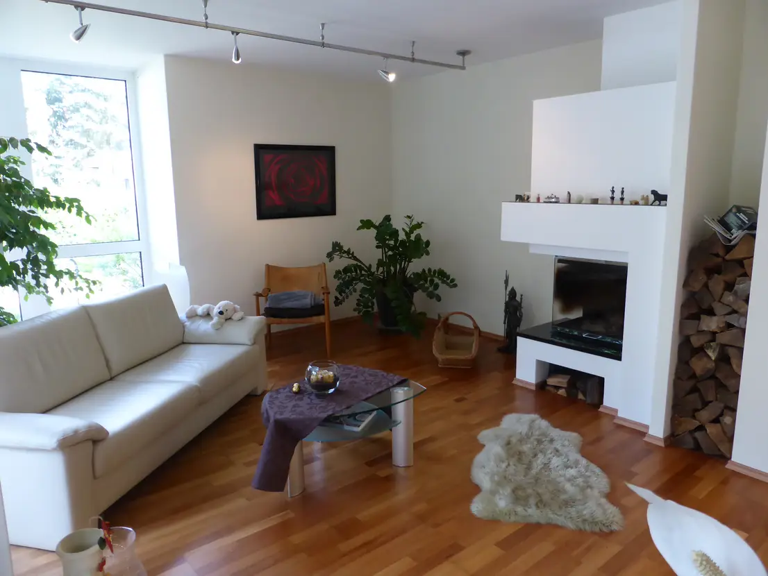 Großzügiges Wohnzimmer mit Kamin und Gartenzugang