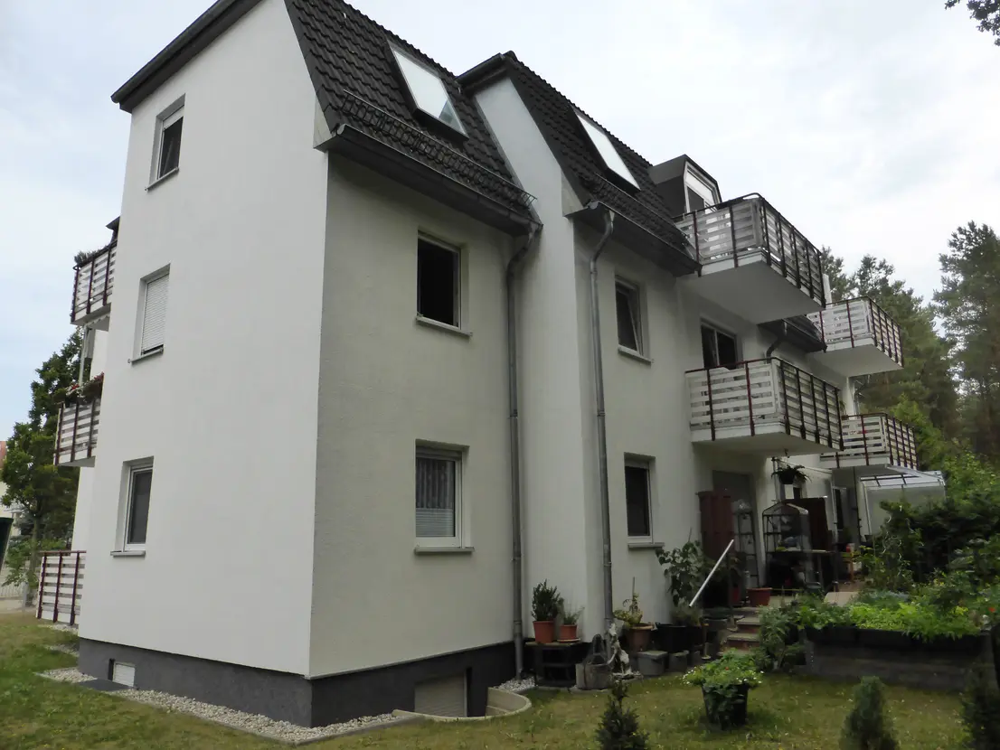 Seitliche Ansicht des Mehrfamilienhauses mit Grünflächen
