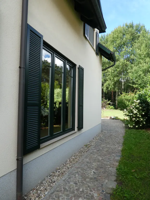 Gepflasterter Gartenweg entlang der Seitenfassade des Hauses