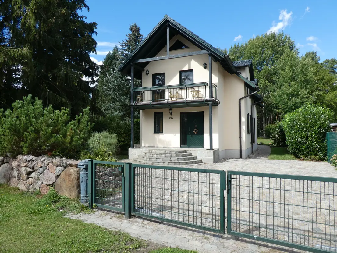 Vorderansicht des Einfamilienhauses mit Garten und Zufahrt